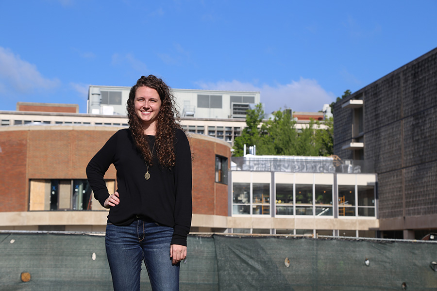 Rachel Brashear, a fourth-year civil engineering undergraduate, stands in front of the Van Leer Building and the under-construction Interdisciplinary Design Commons. Brashear has been working as the project's on-site engineer with Gilbane Building Company. (Photo: Jess Hunt-Ralston)
