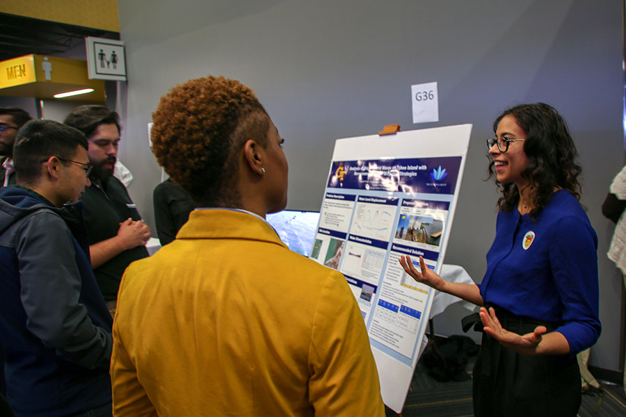 Civil engineering undergraduate Diana Sacks, right, talks about her senior design project during the Capstone Design Expo Dec. 4. Sacks, Vincent Harvey, Christian Mosely and Melissa Osgoodby proposed rehabilitating a century-old existing jetty to protect the Tybee Island shoreline from the wake caused by container ships entering the Savannah River. (Photo: Amelia Neumeister)