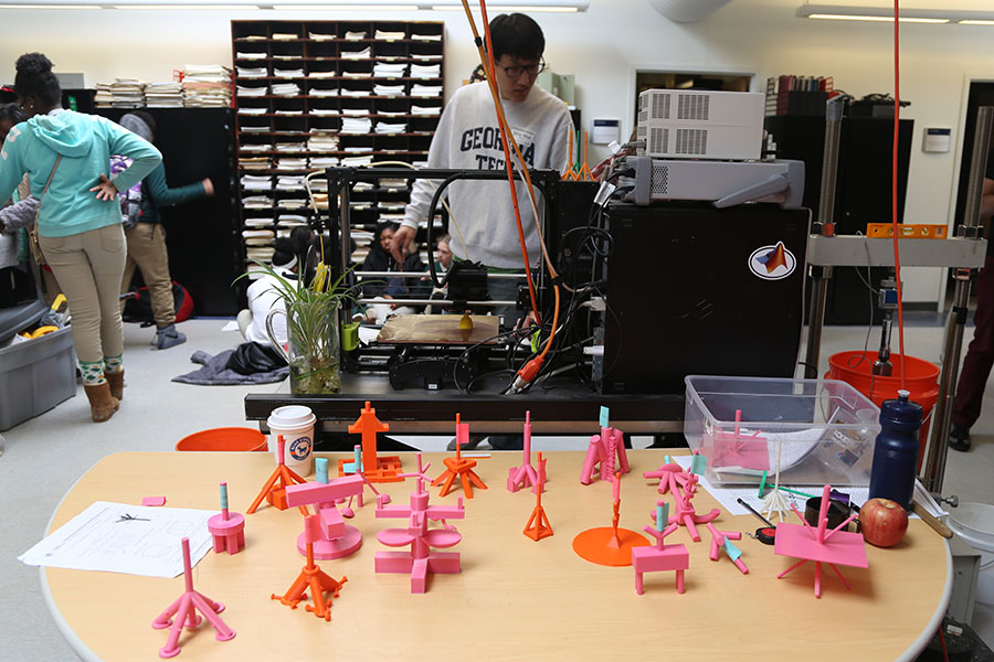 Post-doctoral fellow Jong Muk Won sets up testing on the deep-pile foundation models designed by seventh-graders at Drew Charter School. In the foreground are several of the teams’ designs.
