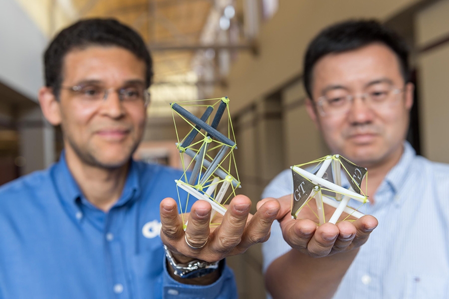 Georgia Tech researchers Glaucio Paulino, left, and Jerry Qi hold 3-D printed objects that use tensegrity, a structural system of floating rods in compression and cables in continuous tension. They’ve developed a new way to create structures with “memory” that can expand dramatically when heated. (Photo: Rob Felt)